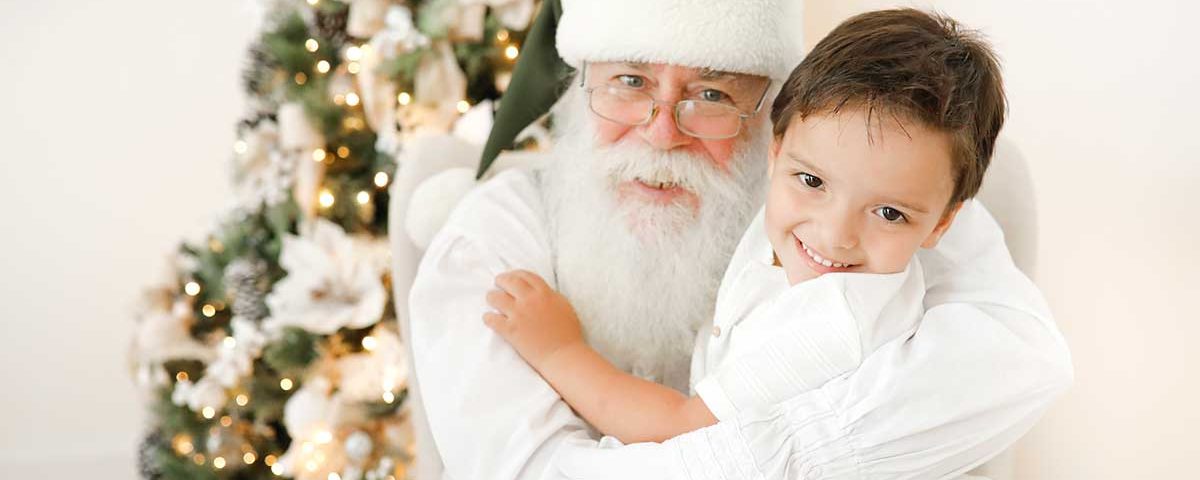 Papai Noel abraçando menininho bonito